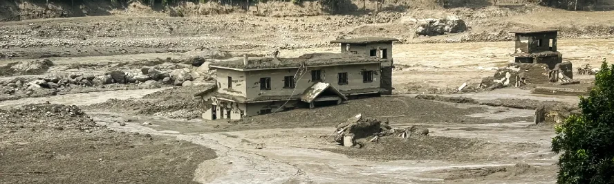 Flood-affected area in Nepal with damaged homes and mud-covered land