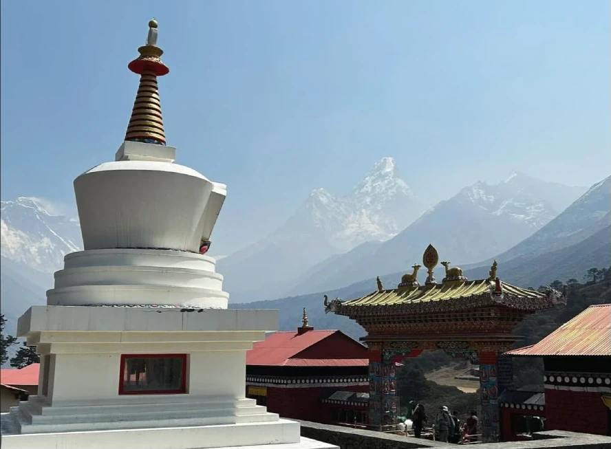 Buddhist stupa and monastery with snow-capped Himalayan peaks in Nepal's Everest region.