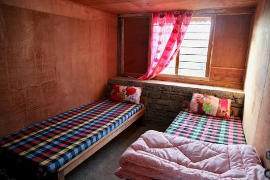 Basic teahouse room with twin beds on the Everest Base Camp Trek in March.