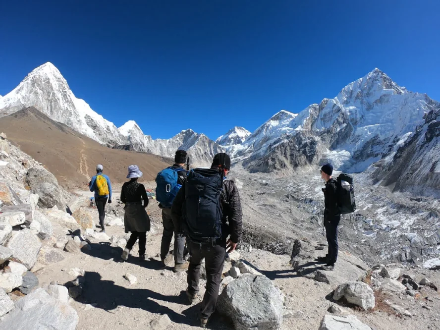 Trekkers hiking toward Kala Patthar through the rugged Everest region with snow-covered Himalayan peaks