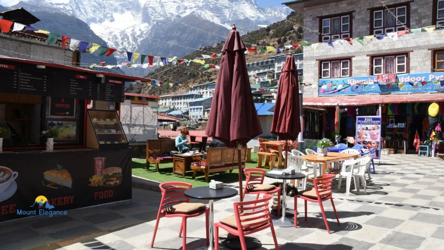 Namche Bazaar village street with cafés, prayer flags, and Himalayan mountains