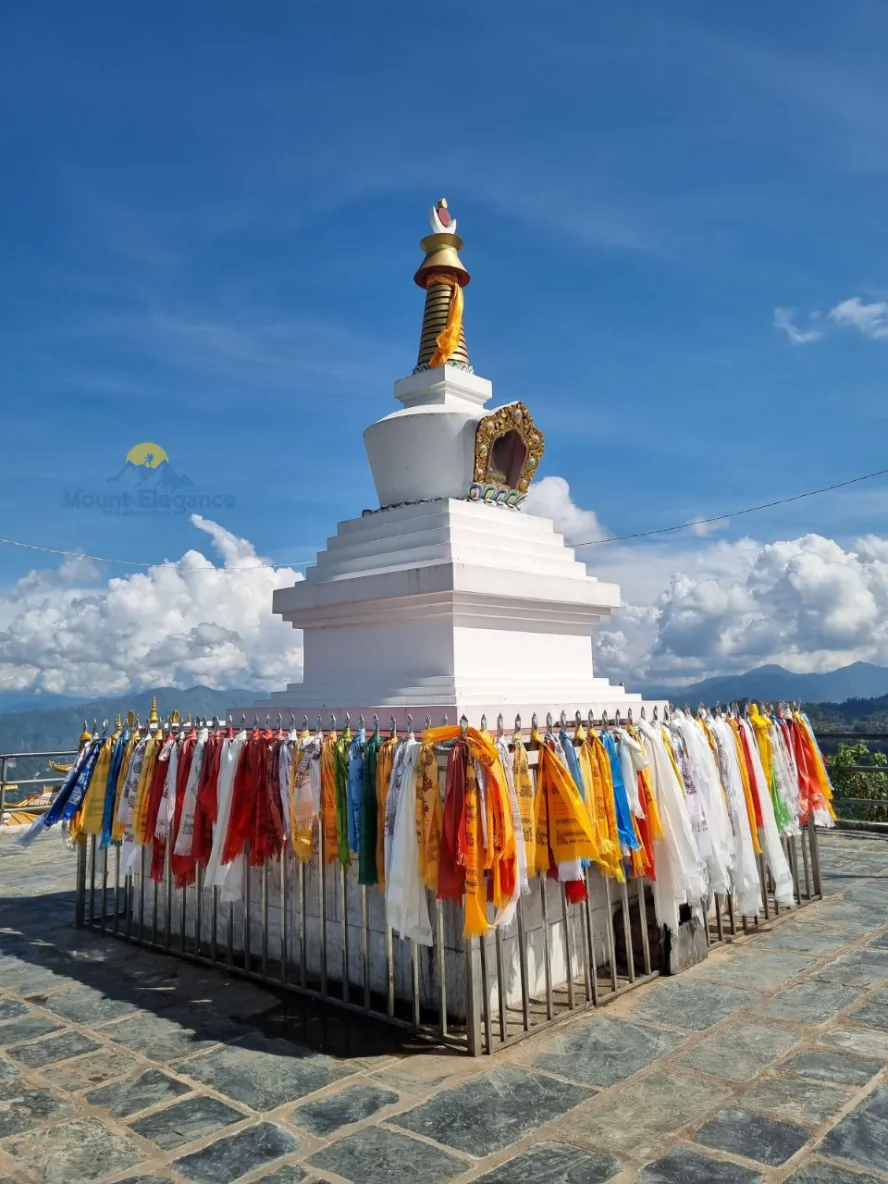 Namche Monastery in Namche Bazaar with a prayer-flag-draped stupa in the foreground.