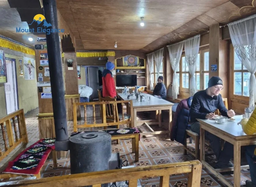 Interior of a teahouse dining room in Phakding with wood stove and seating