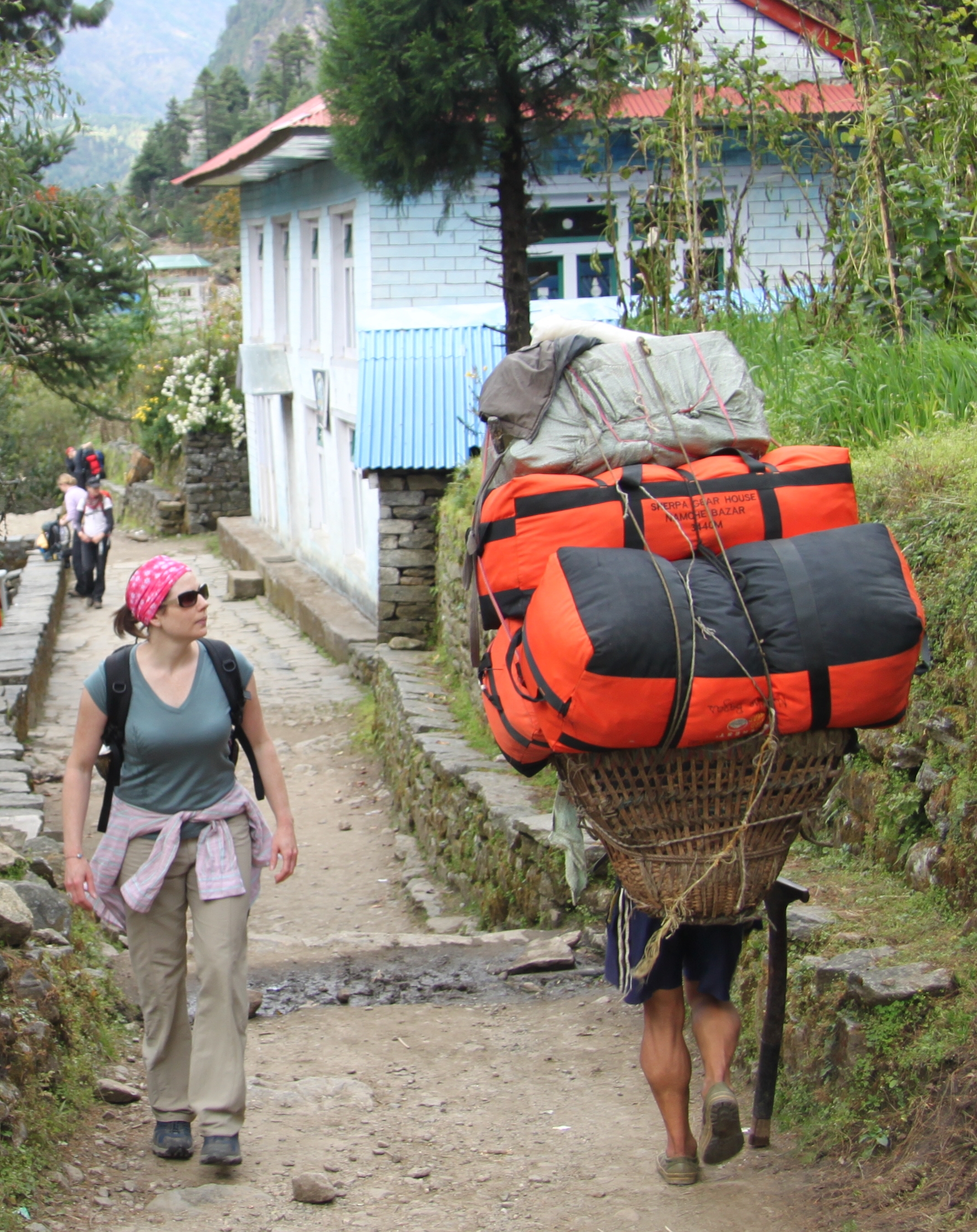 Guide and porter carrying trekking gear on the Everest Base Camp trail in June