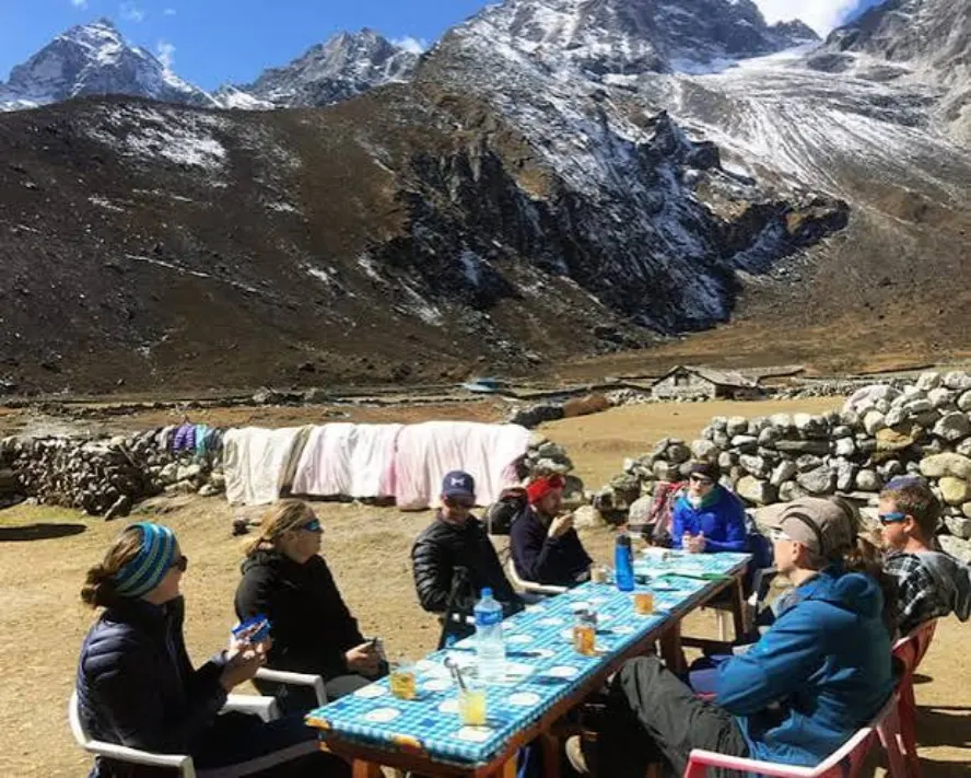 Trekkers enjoying a sunny May day at a Himalayan tea house in Nepal